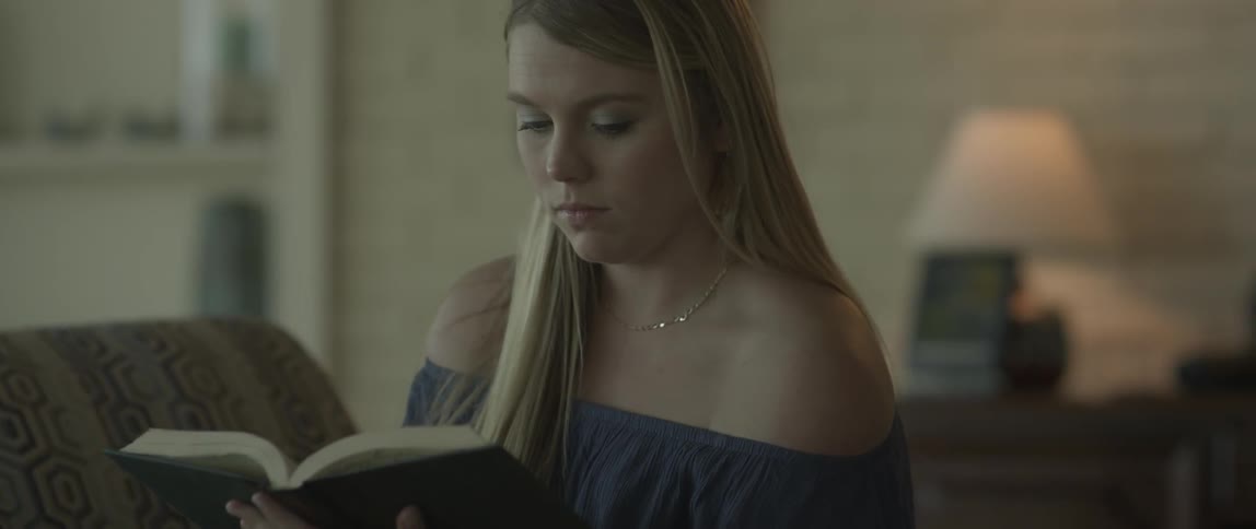 A woman reads a book at home