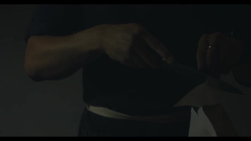 A man cuts paper with a knife