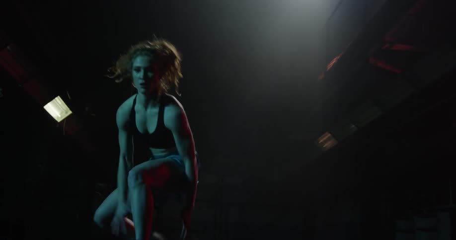 A woman bounces the ball very fast as lights blink