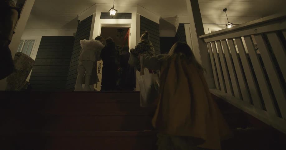 Children in costumes are trick-or-treating on halloween