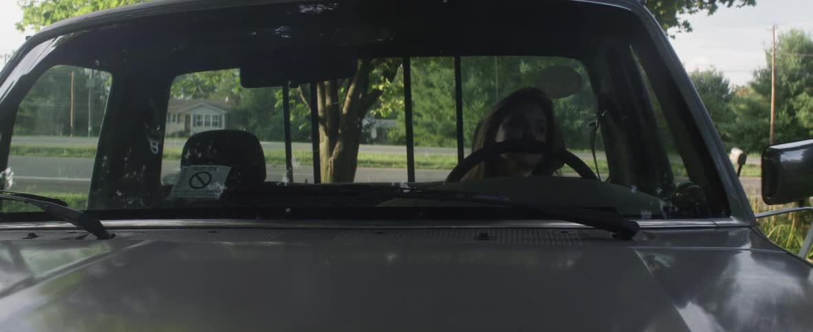 Woman sitting in a truck leans back in her seat