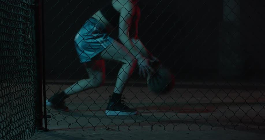 A woman is bouncing the basketball fast