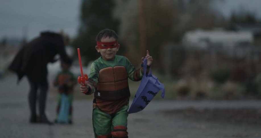 A child runs and smiles while trick or treating