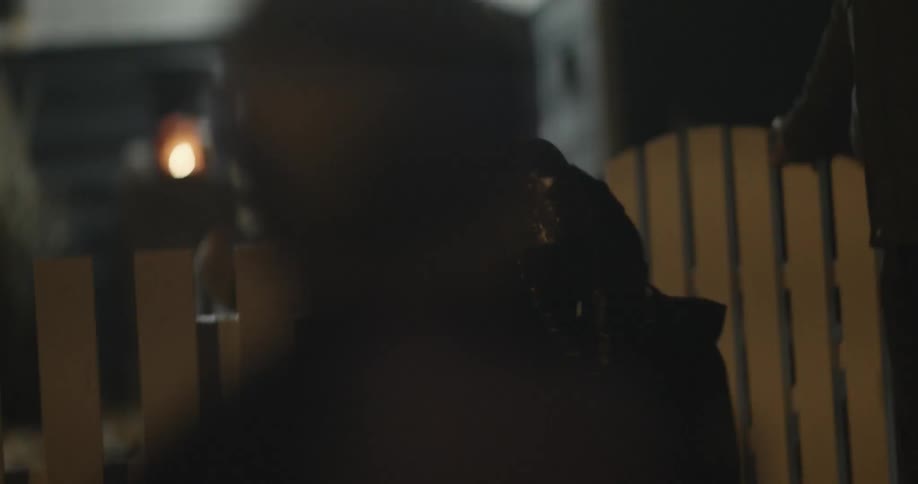 A man is holding a fence gate open for a group of trick-or-treaters