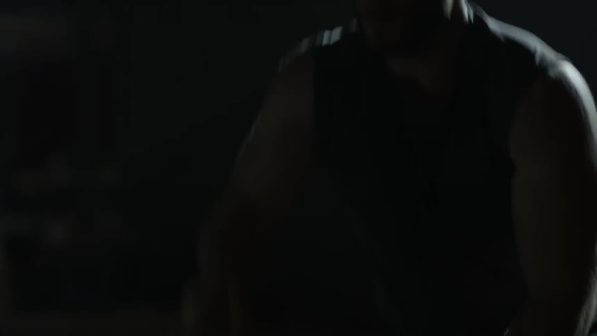 A man is doing rope pulls exercise in a gym