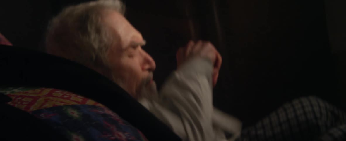 An elderly man falls to the ground next to a bed