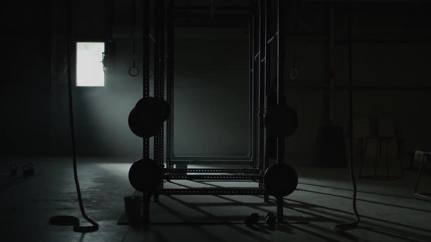 Gym equipment sits in a dark room