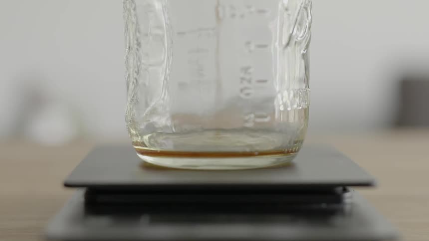 Liquid dripping into a measuring jar set on a scale