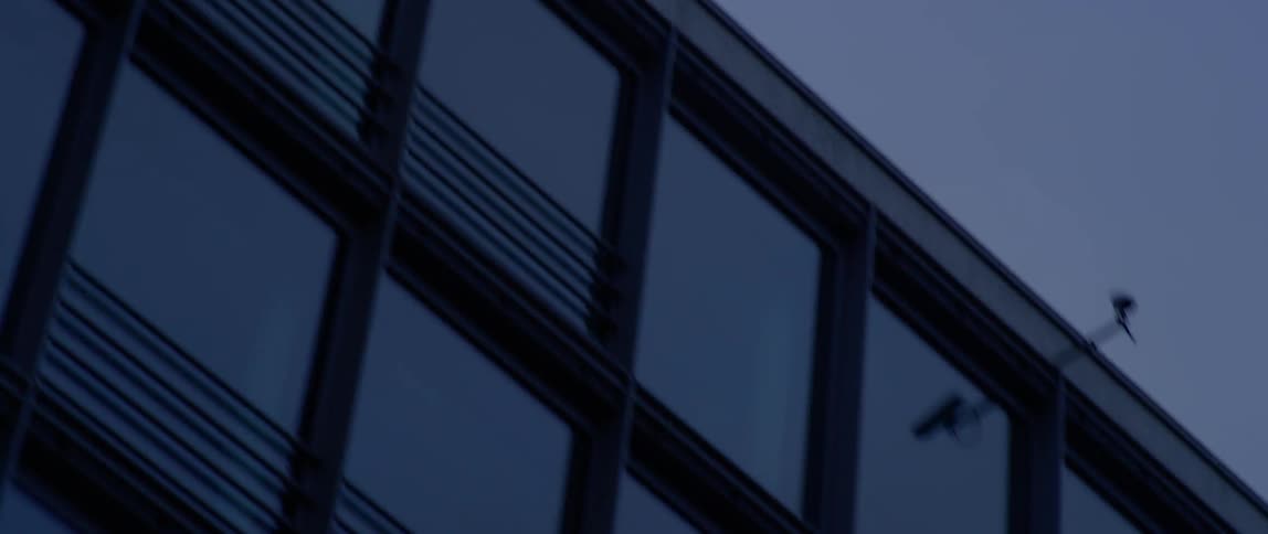 A security camera is positioned on top of a building