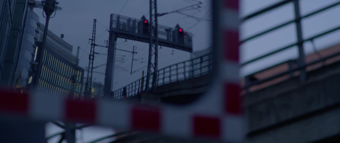Red lights shine above a transit bridge at dusk
