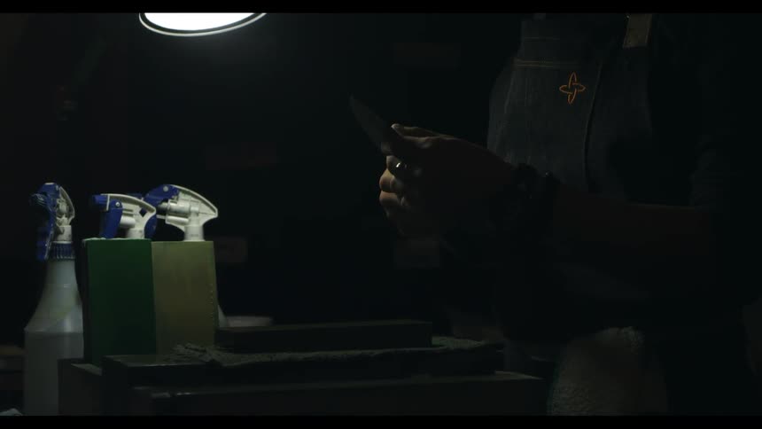 A man holds a knife and rubs the blade