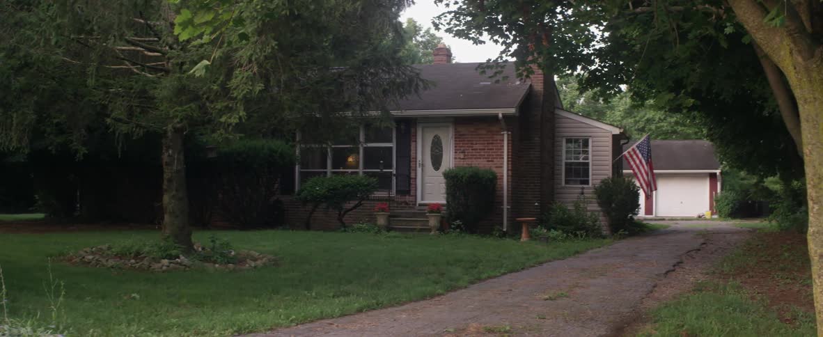 An american flag is mounted on the side of a brick house