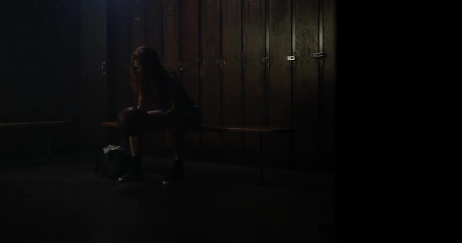 A woman grabs and spins a basketball