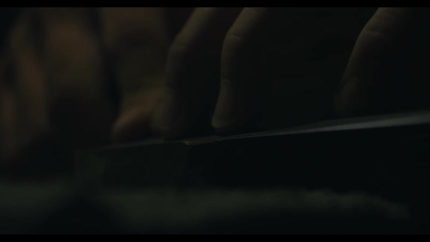 Person's fingers gliding against an object in the dark
