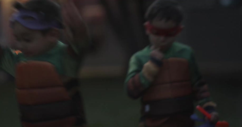 Children in costume laugh as they trick or treat
