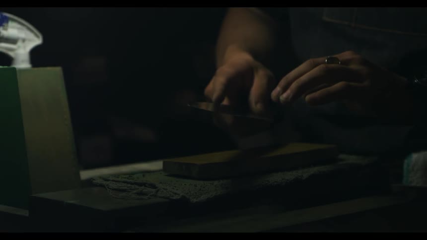 A man is sharpening a knife on a stone
