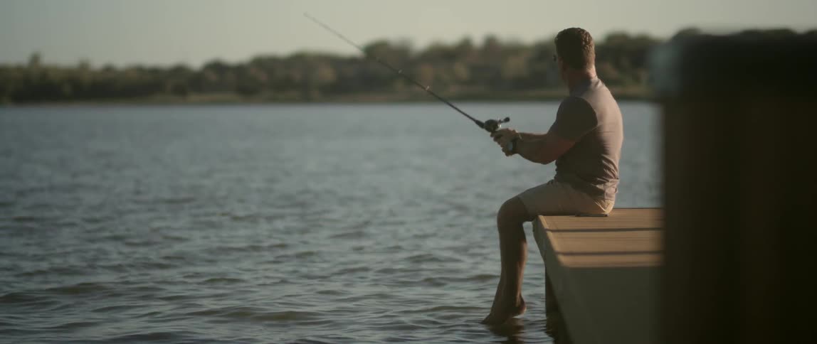 A man sits on the pier fishing
