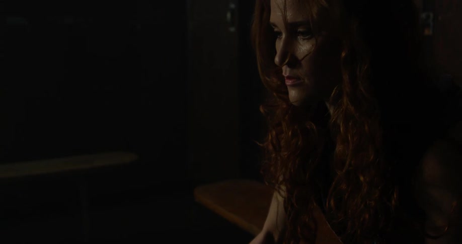 A woman looks down in the dark