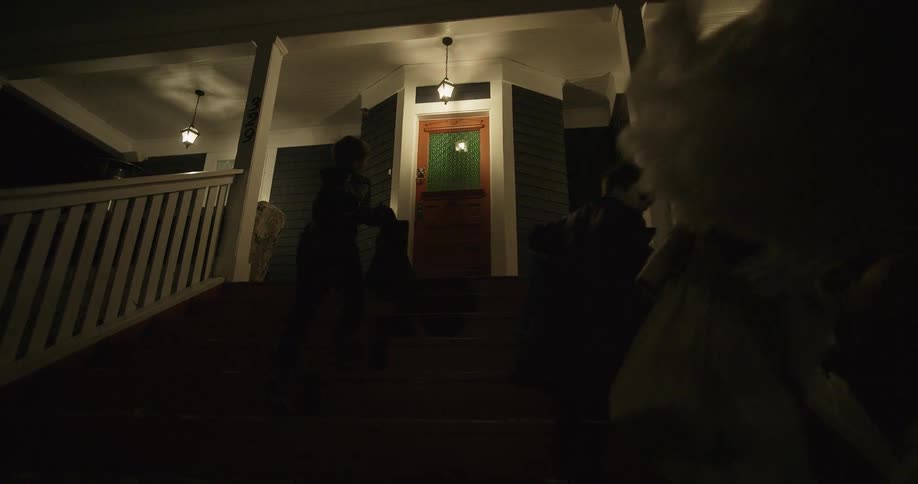Children walk up front steps to trick or treat