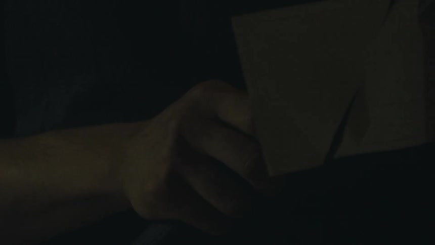 A man is pulling a knife from a cloth bag