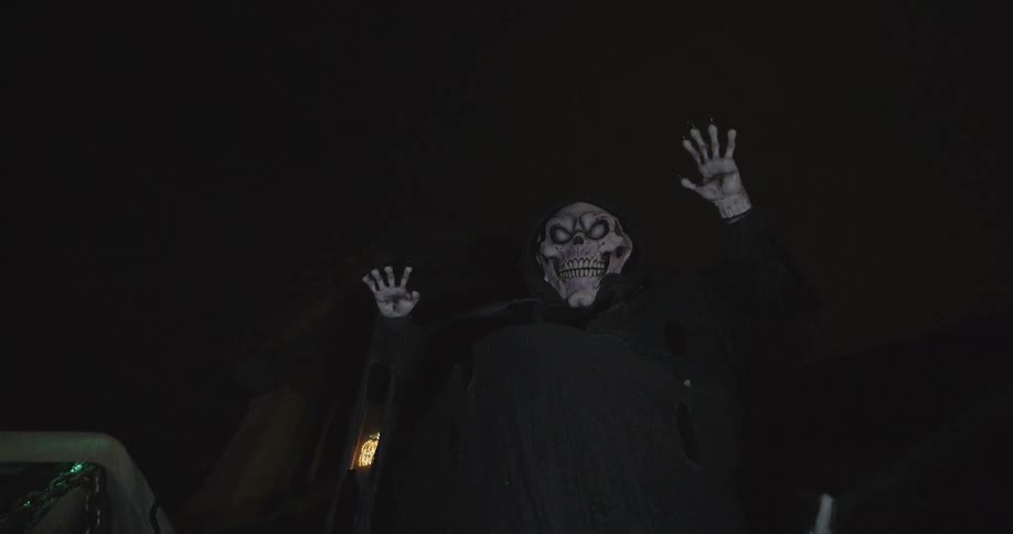 A grim reaper decoration hangs outside a house