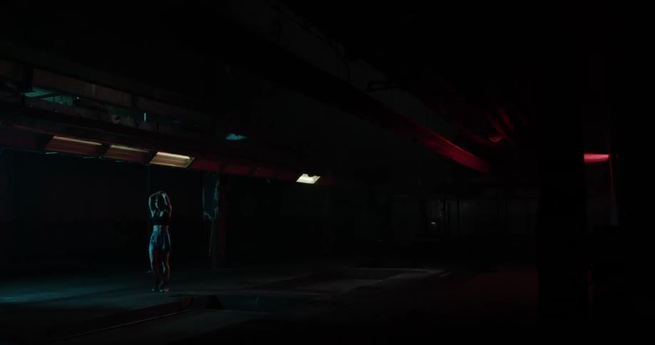 A woman walks around and stretches in a gym