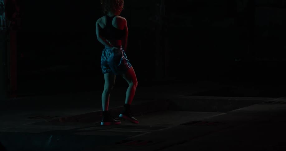 A woman dribbles a basketball between her legs