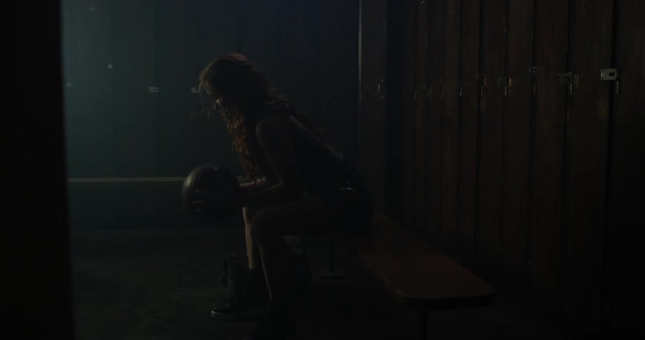 A woman spins and dribbles a basketball sitting on the bench