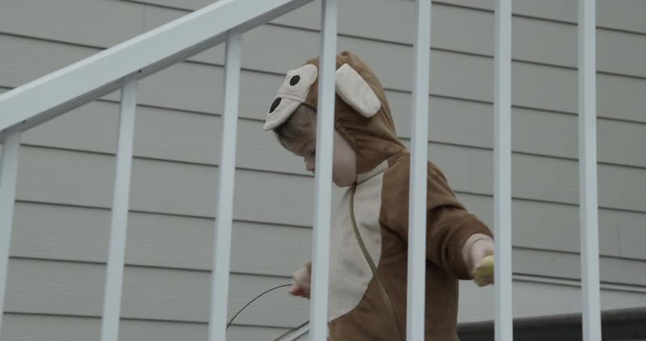 A boy in costume climbs down the steps
