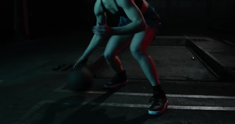 A woman is dribbling a basketball up close