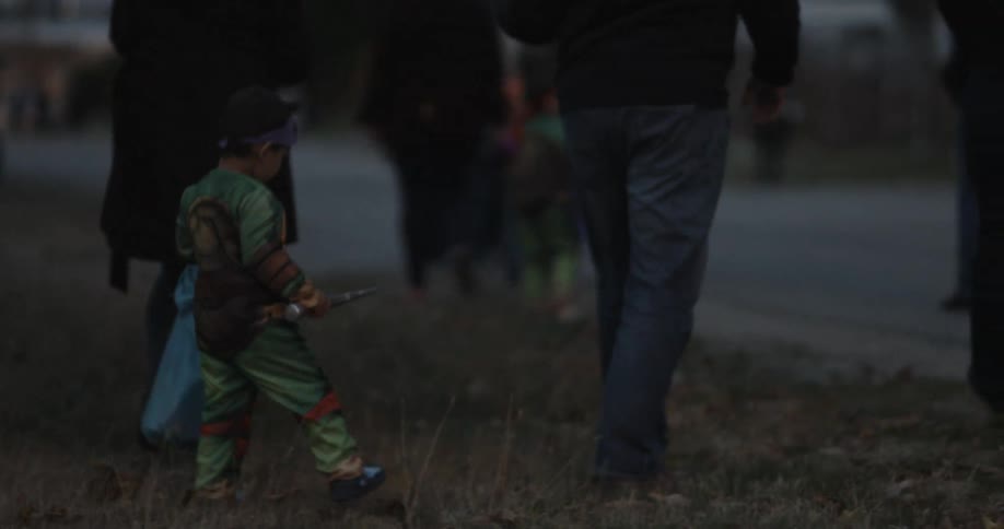 Adults walk children in costume to trick or treat