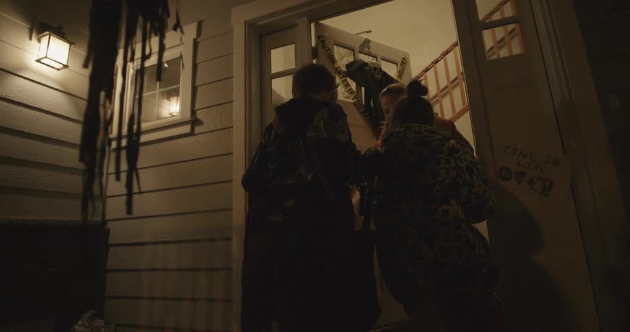 Children trick or treat at a front door