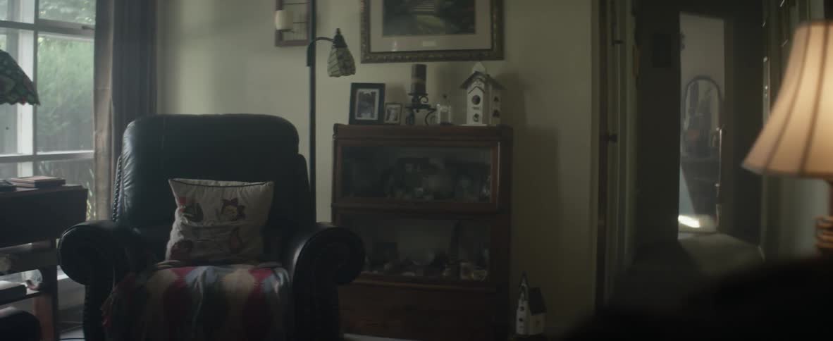 A recliner and knick-knacks sit motionless in a living room