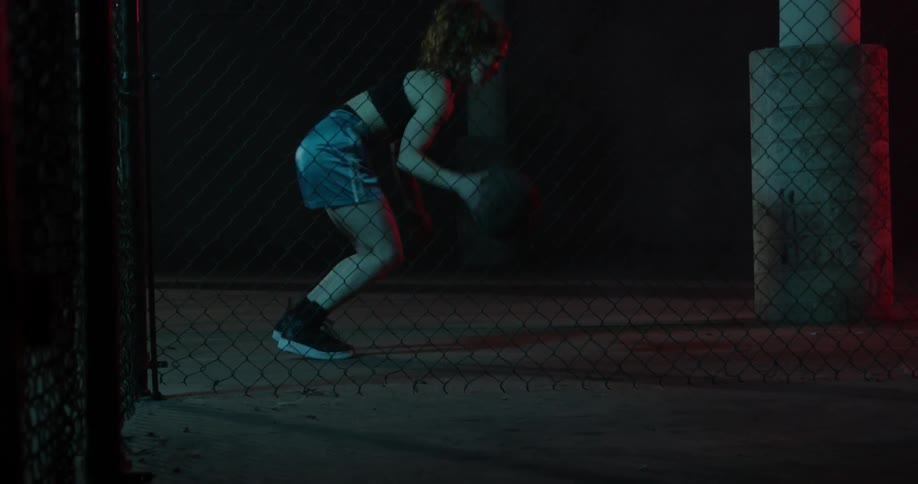 A woman practices dribbling a basketball