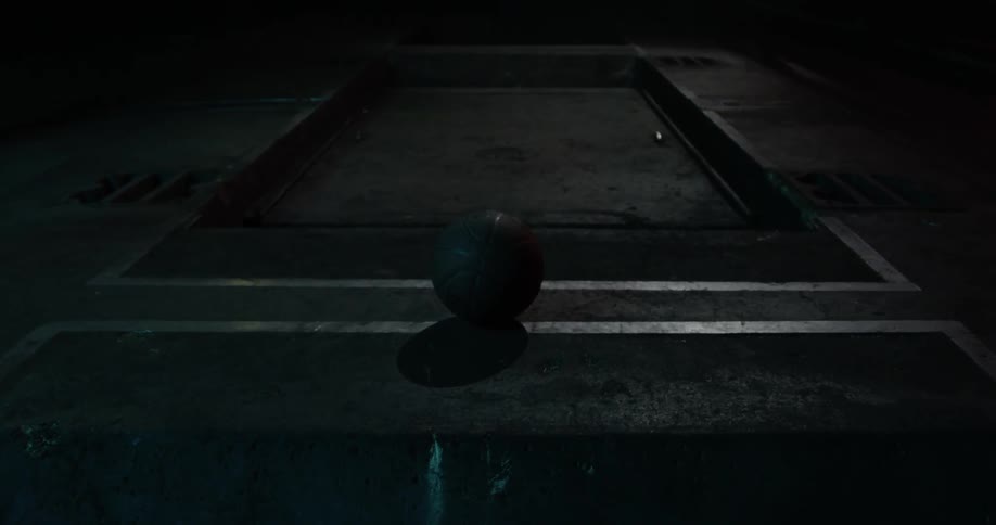 A basketball is sitting still on a the concrete