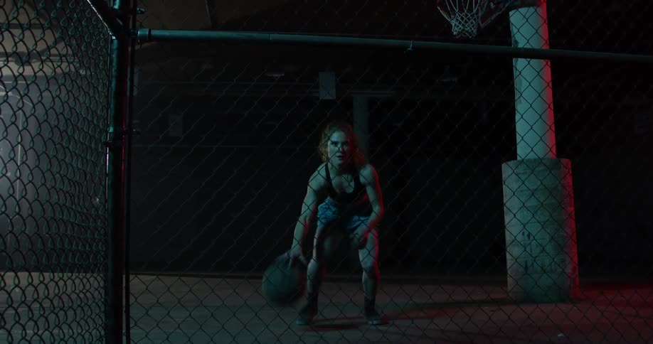 A woman dribbles a ball between her legs