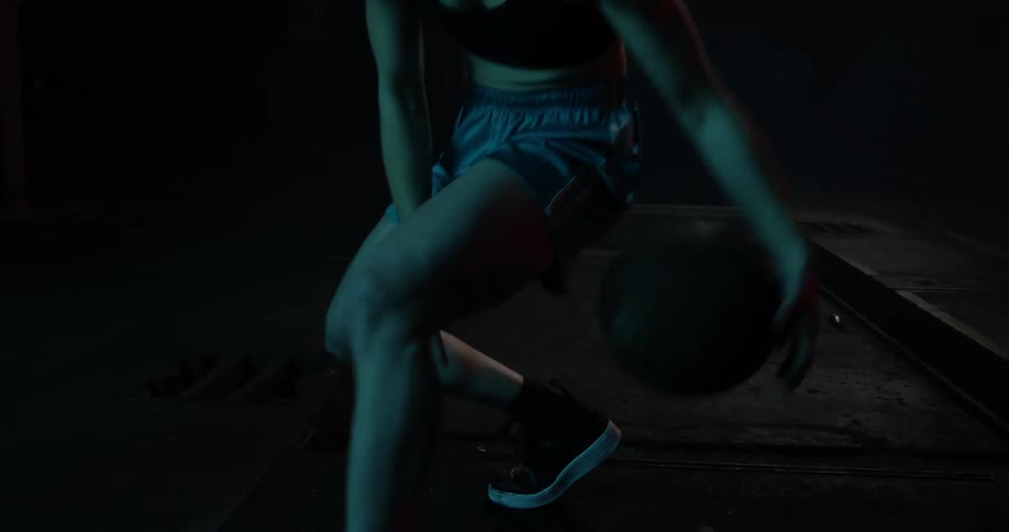 A lady dribbling a basketball up close