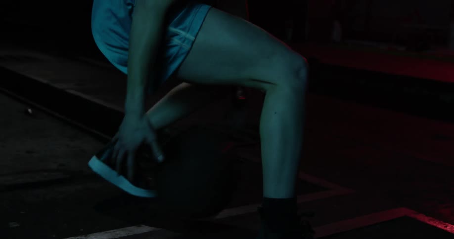 A woman is dribbling a basketball between her legs