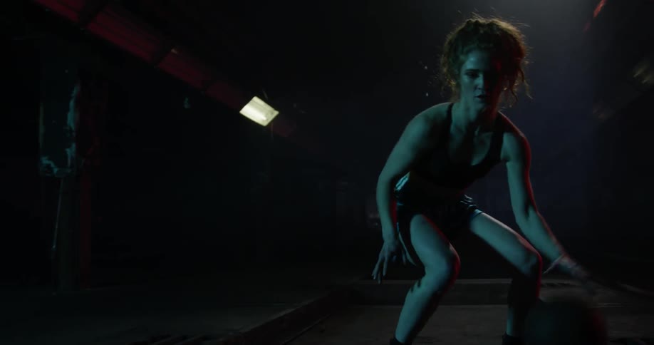 A woman dribbles a basketball between her legs