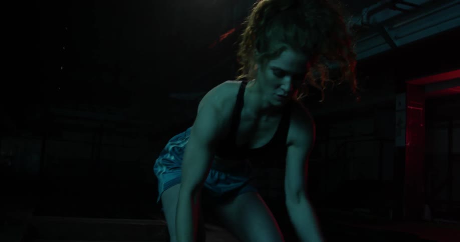 A woman dribbles a basketball between her legs
