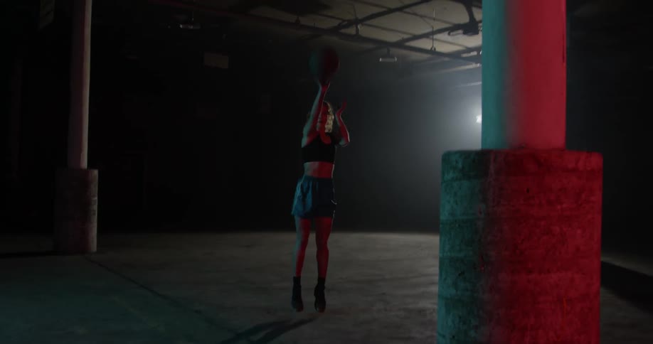A woman practices basketball alone