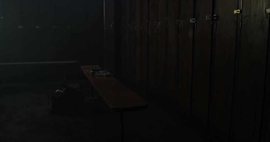A bag and clothes sit in a locker room