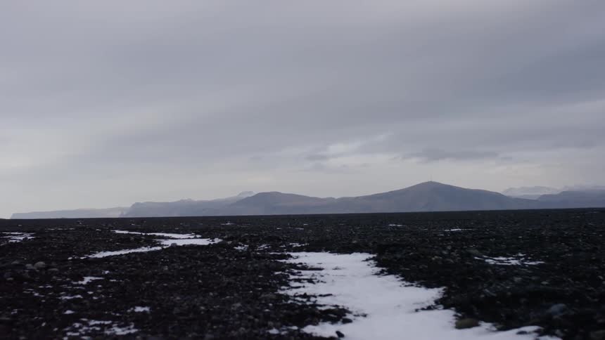 A mountain range in the distance on an overcast day