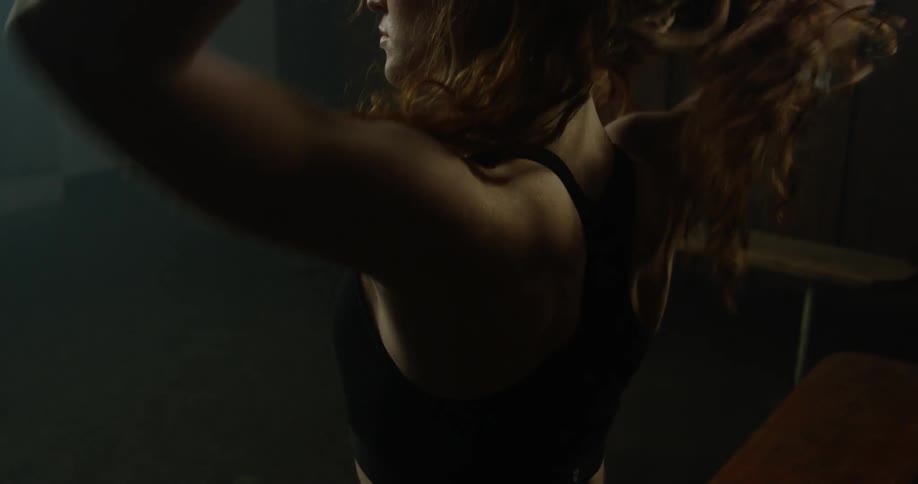 Woman with long hair pulls her top off over her head