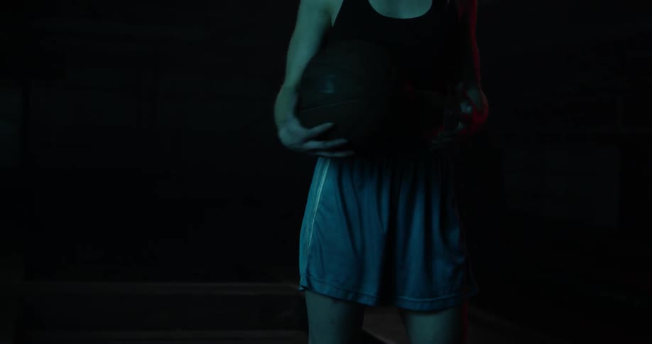 Woman sliding a basketball around her back to her other hand
