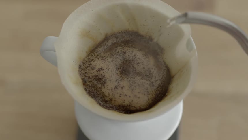 Hot water is being poured over tea power placed in the cup