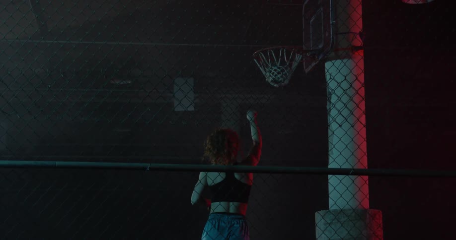 A woman is dribbling a basketball and shooting it