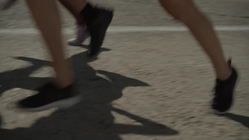 Three people jog alongside a street