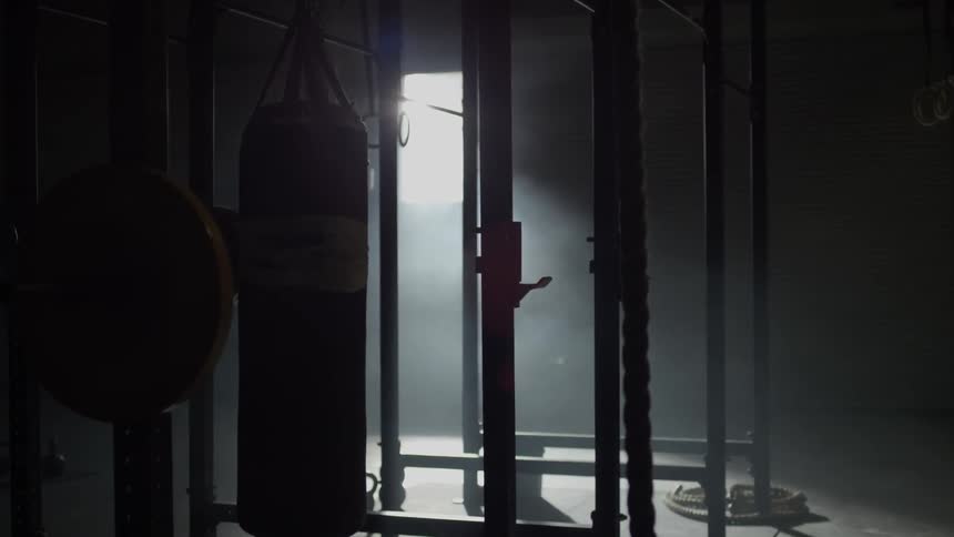 The gym is dark filled with equipment