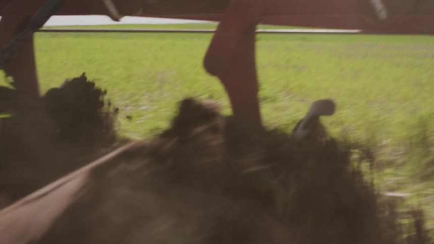 Farm equipment rips up the soil and grass